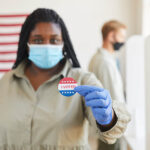 Blurred,Portrait,Of,African-american,Woman,Holding,I,Voted,Sticker,While